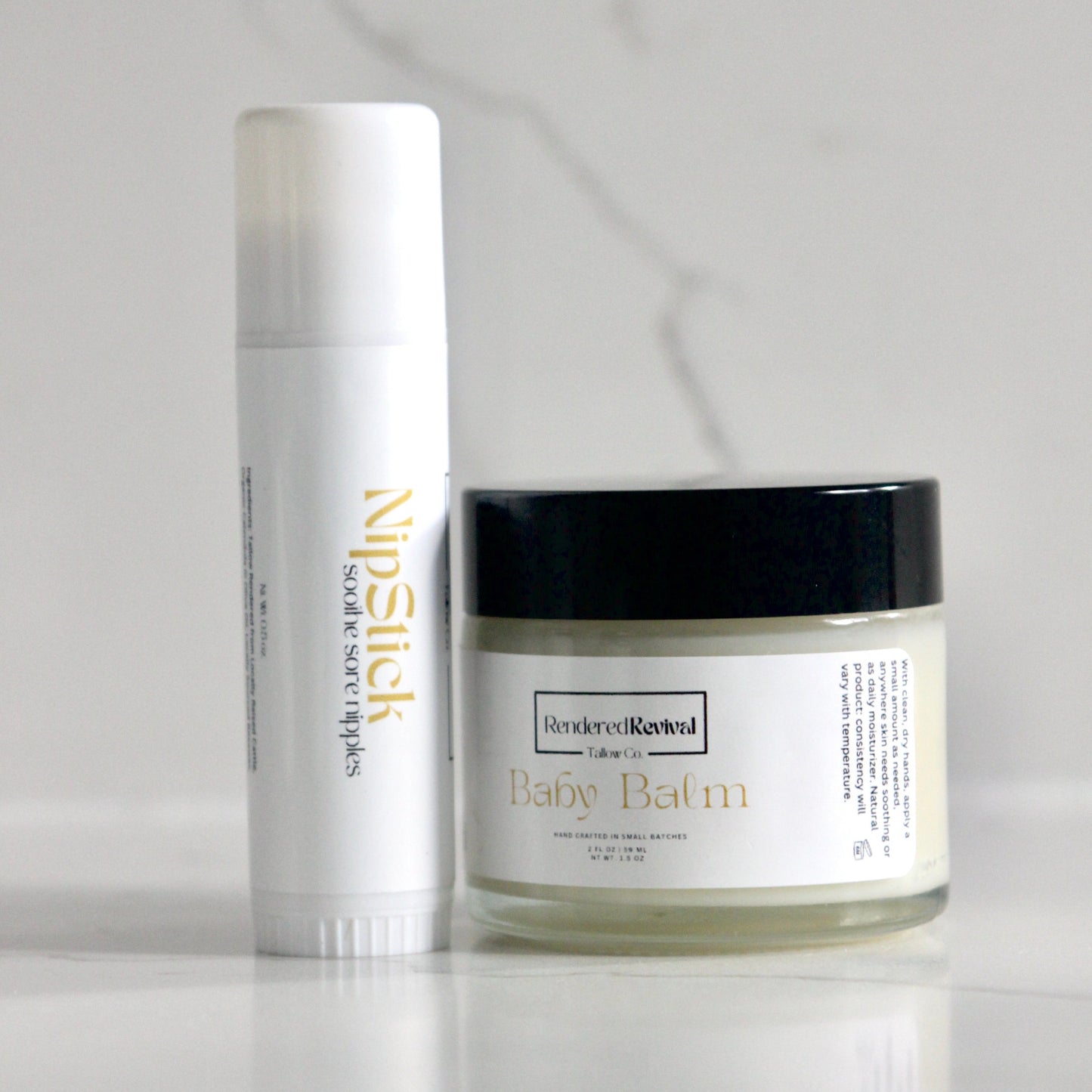 Captivating image showcasing a 2 oz jar of nourishing baby balm, elegantly presented with a clear jar, black lid, and white label featuring yellow font, accompanied by a 0.5 oz nip stick in a sleek white tube positioned vertically to the left, creating a harmonious skincare pairing against a backdrop of pristine white quartz