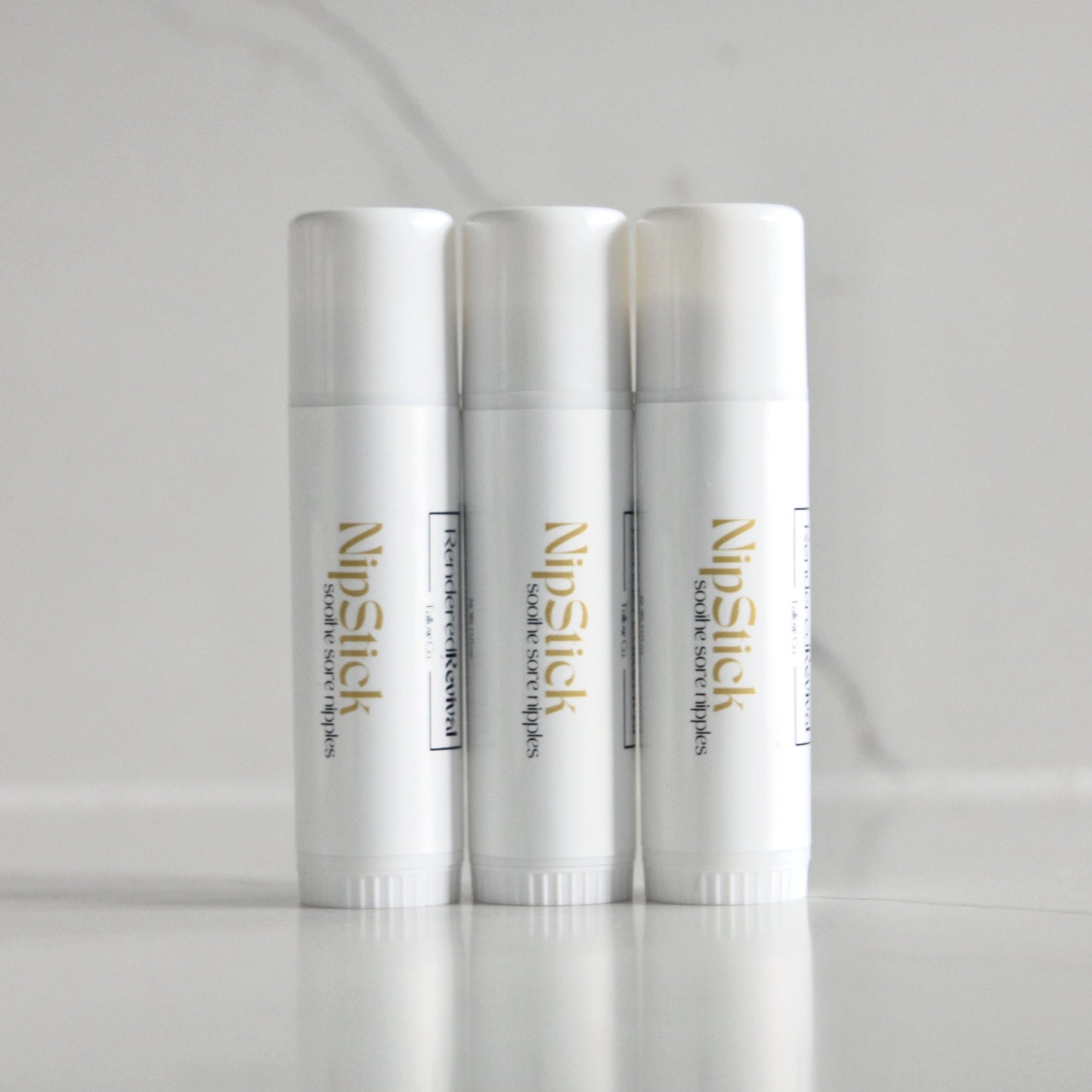 Harmonious trio of 0.5 oz nip sticks standing upright in a line, each encapsulated in a sleek white tube featuring a white label and eye-catching yellow font, creating a visually appealing arrangement against a clean and inviting background.